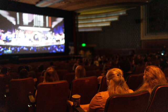 video being shown on screen in theater.