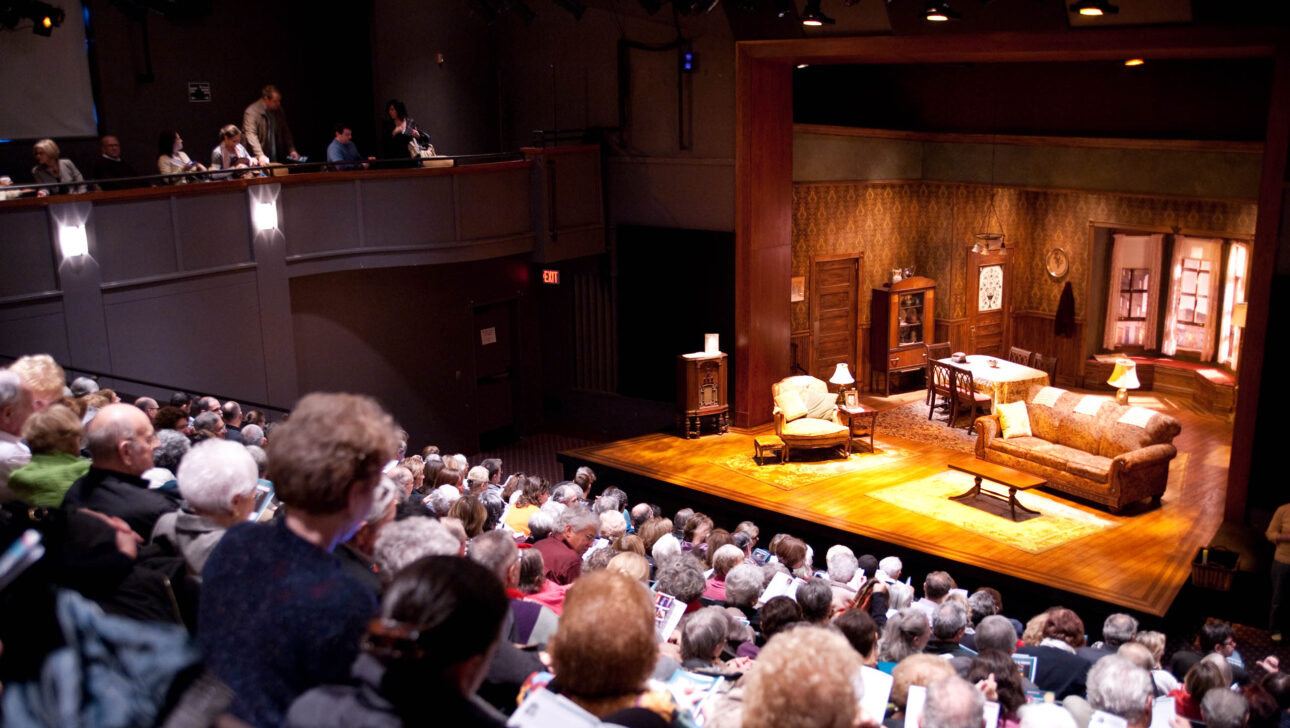 full crowd in theater seating during intermission.