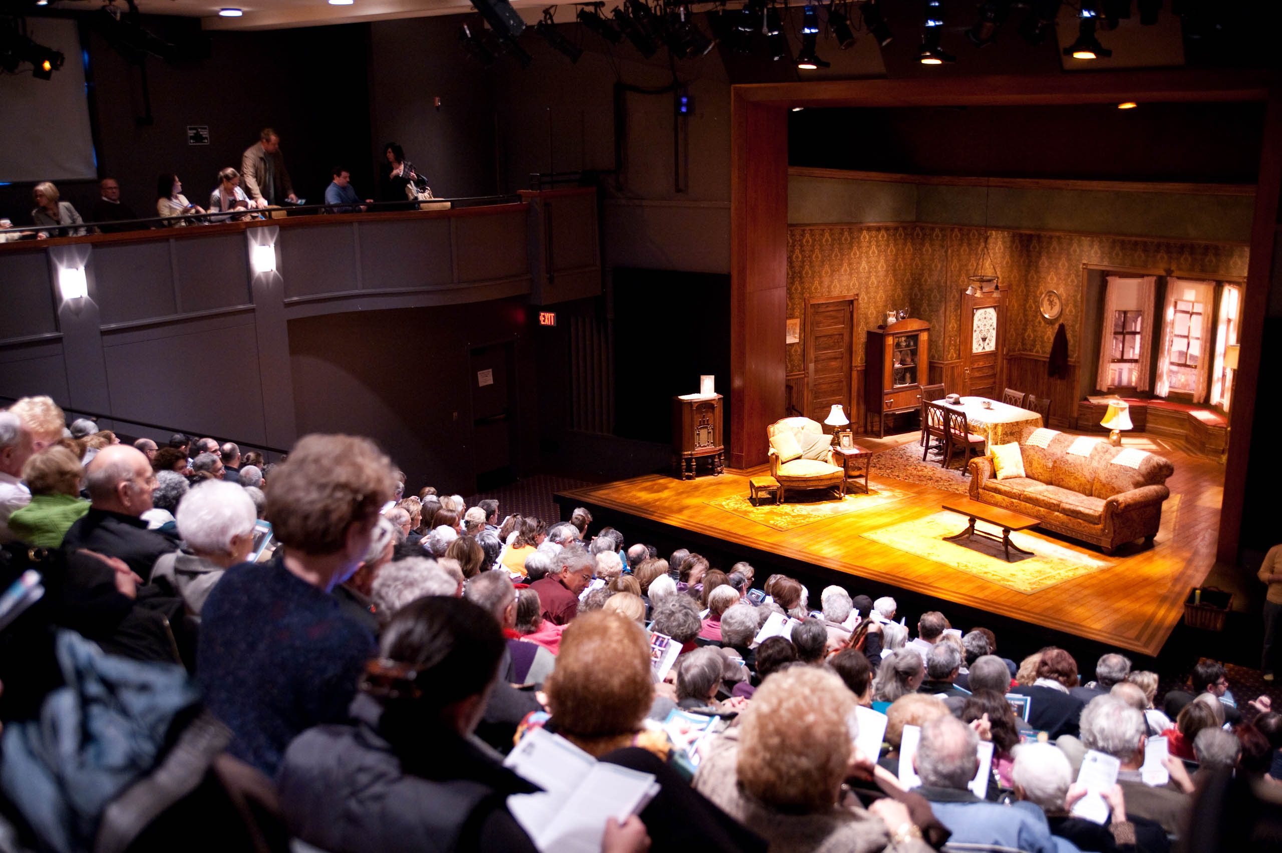 full crowd in theater seating during intermission.