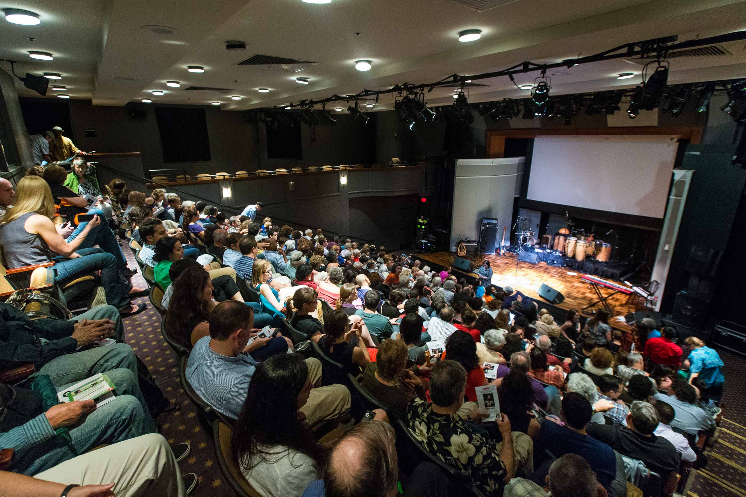 full crowd in theater seating during intermission.