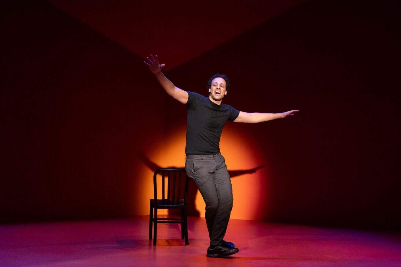 Ari'el Stachel stands alone on stage in a spotlight as he performs Out of Character