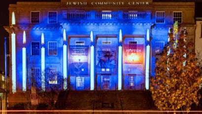 front of edcjcc with menorah projected on wall.