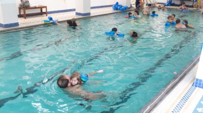 people swimming in and indoor pool.