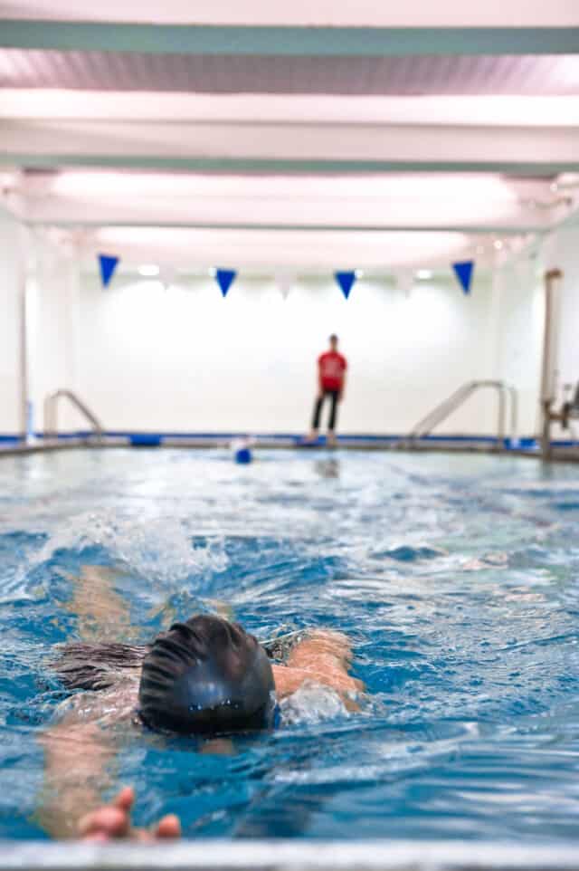 person swimming in an indoor pool.