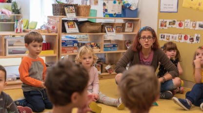 teacher teaching class of young children.