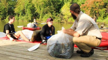 People in kayaks collecting garbage