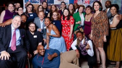 Group photo of people in front of step and repeat