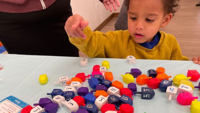 Close up of child playing with dreidels