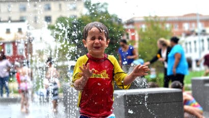 Young boy getting wet at splash park