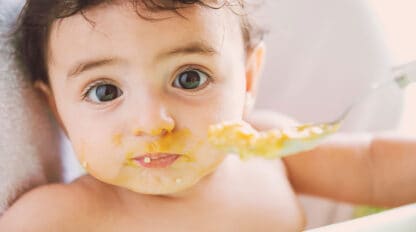 Baby eating pureed food with a spoon