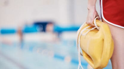 Image of lifeguard holding pool float