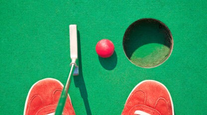 Red shoes playing mini golf